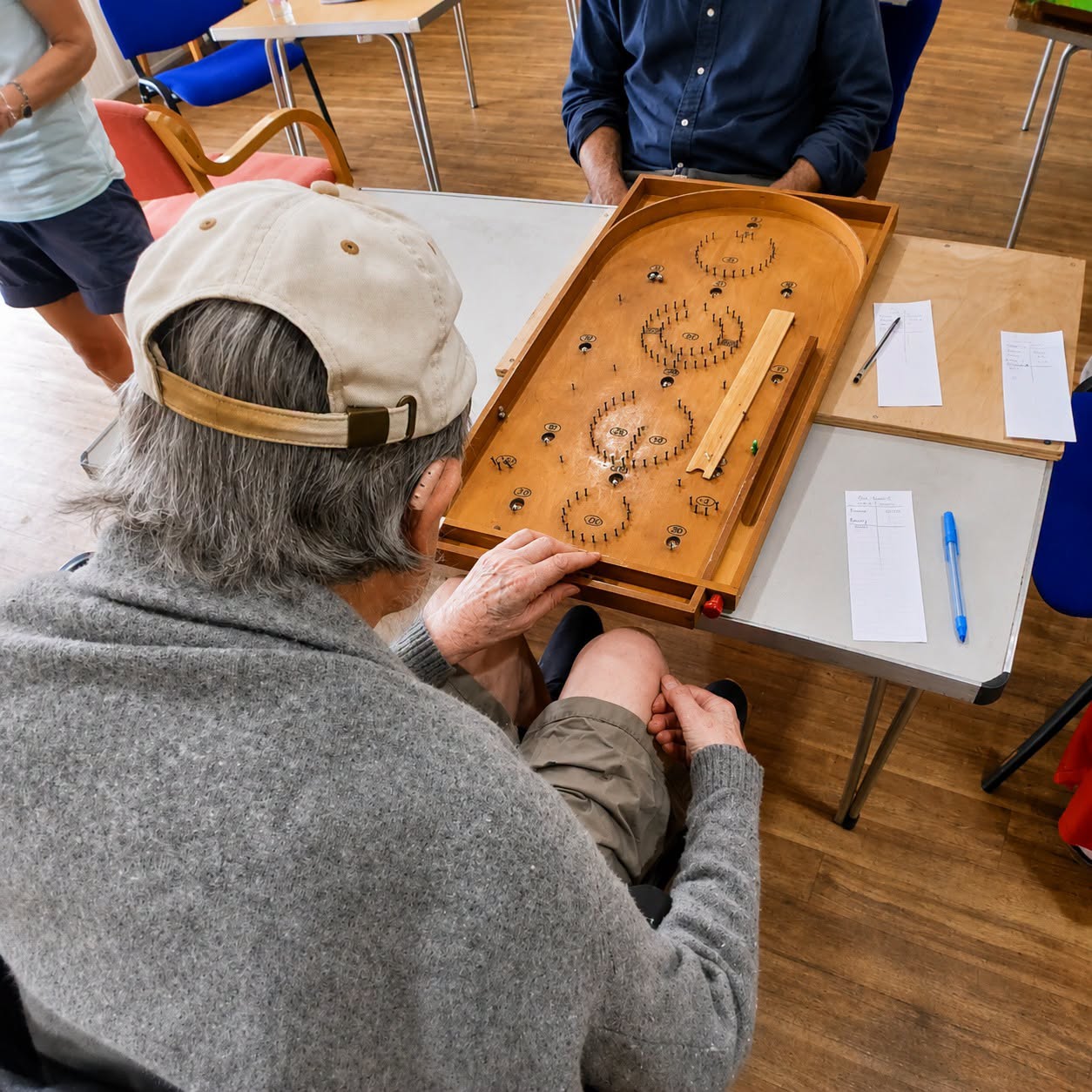 Barry playing a wooden tabletop game at the community event
