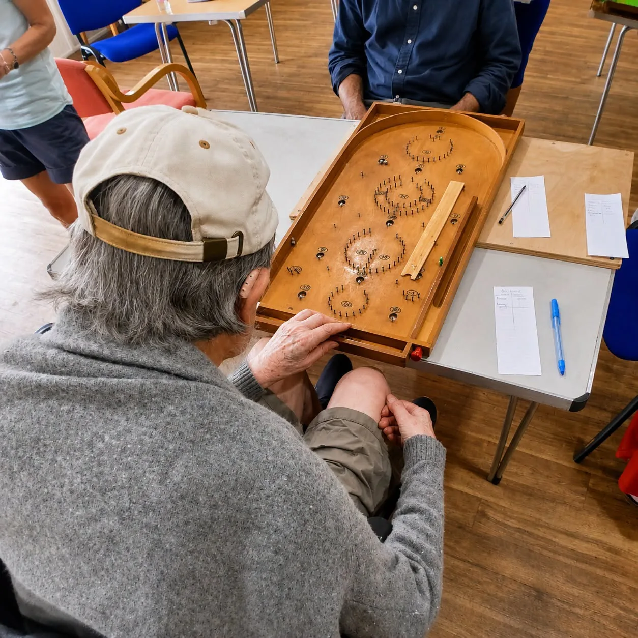Barry playing a wooden tabletop game at the community event
