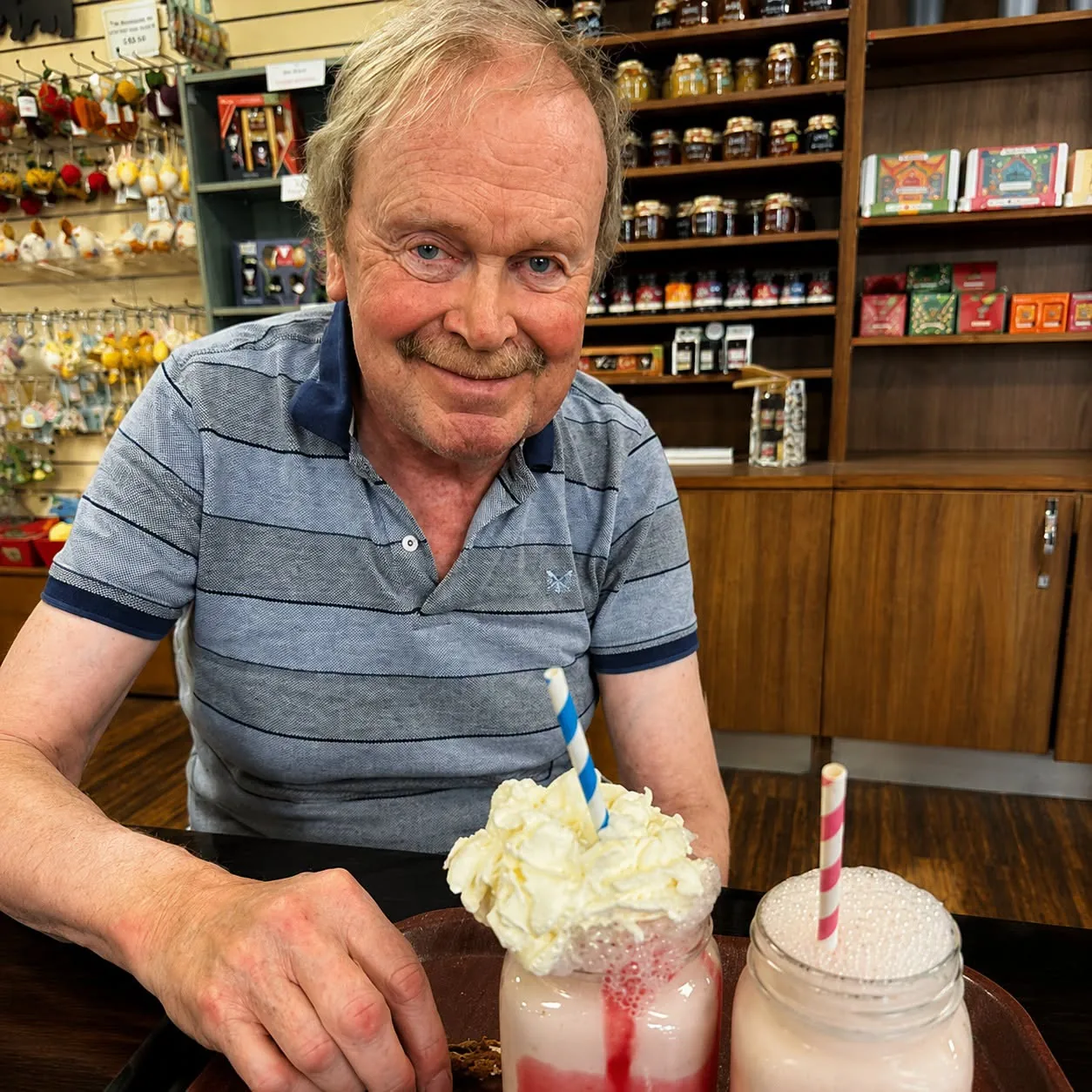 Alan smiling with a strawberry milkshake during a visit to Plymouth Garden Centre