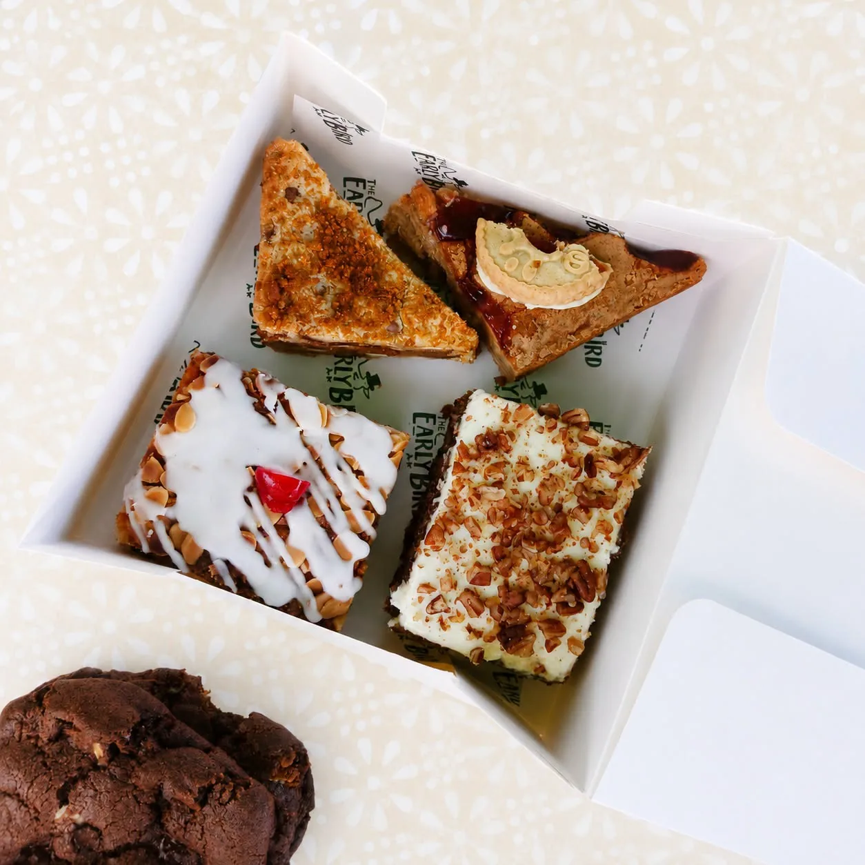 A box containing four cakes selected from the Early Bird stall