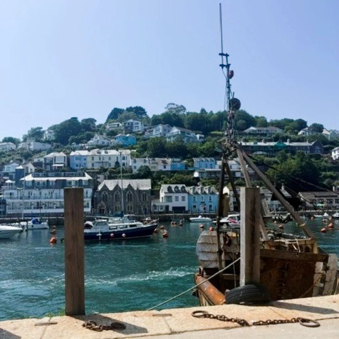 Boats and waterfront buildings around Looe Harbour on a sunny day