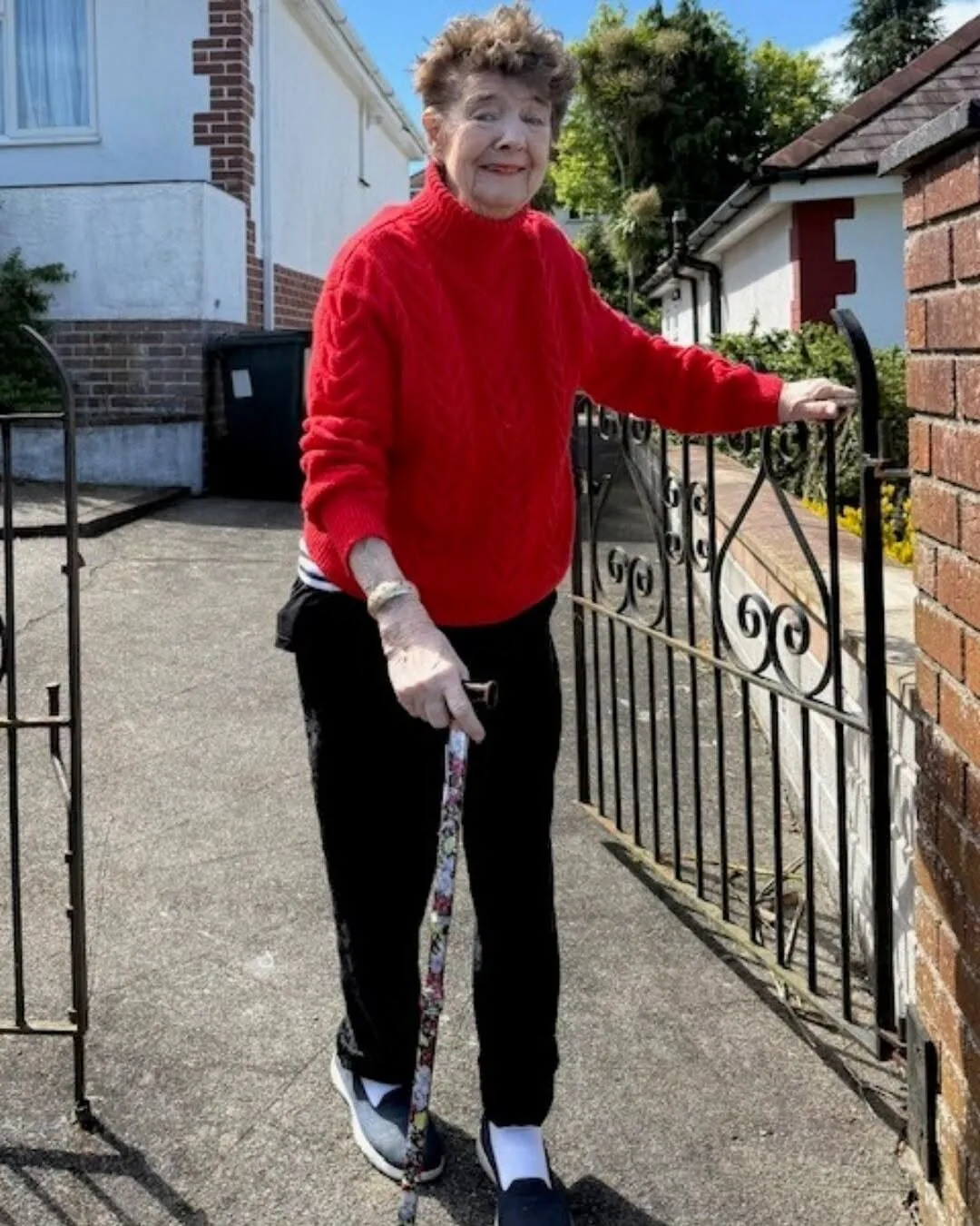 Pam smiling outside her home before a supported community outing in Torquay