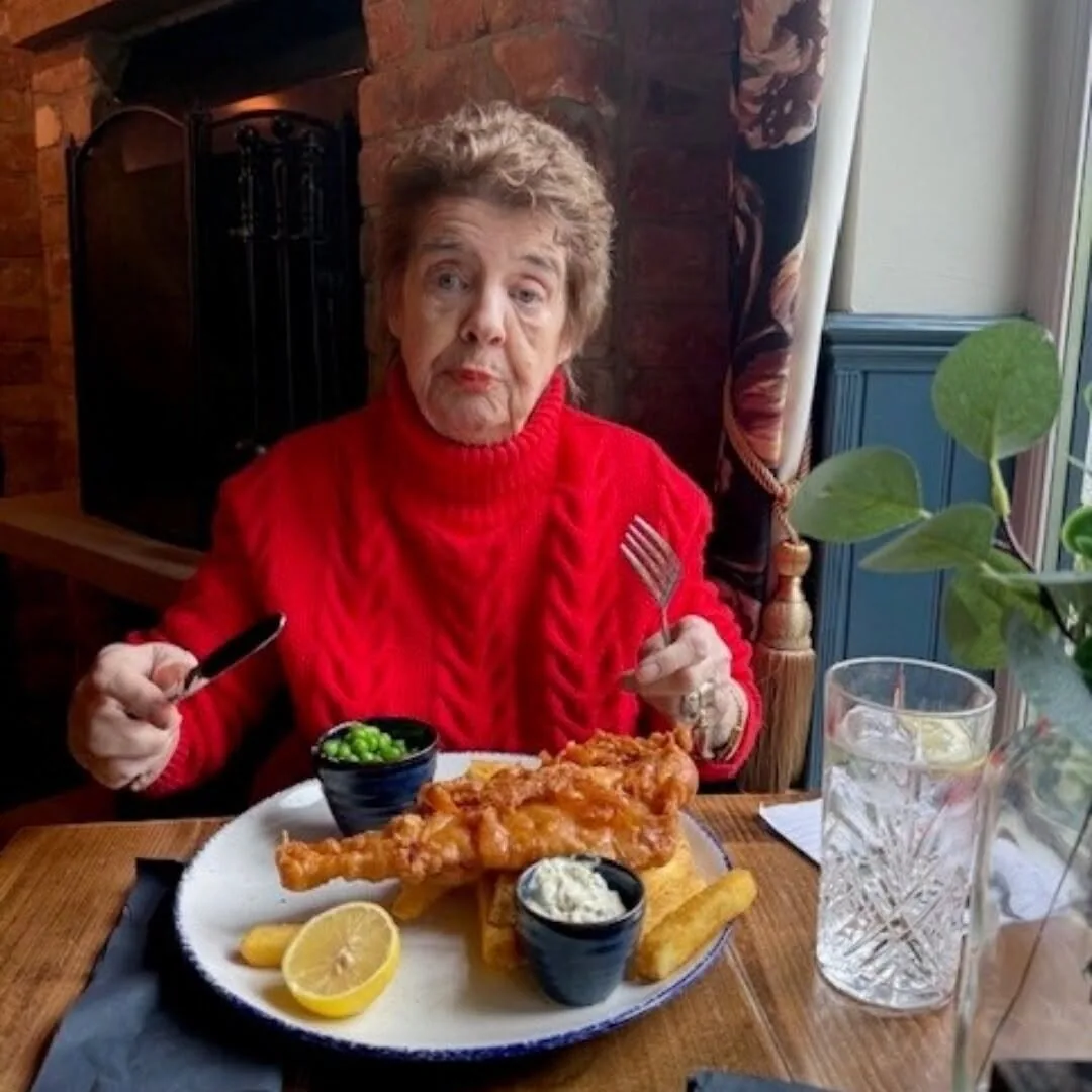 Pam enjoying fish and chips during a supported lunch outing in Torquay